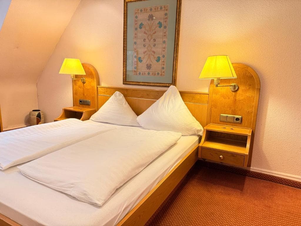 Doppelzimmer mit Holzbetten und Leselampen